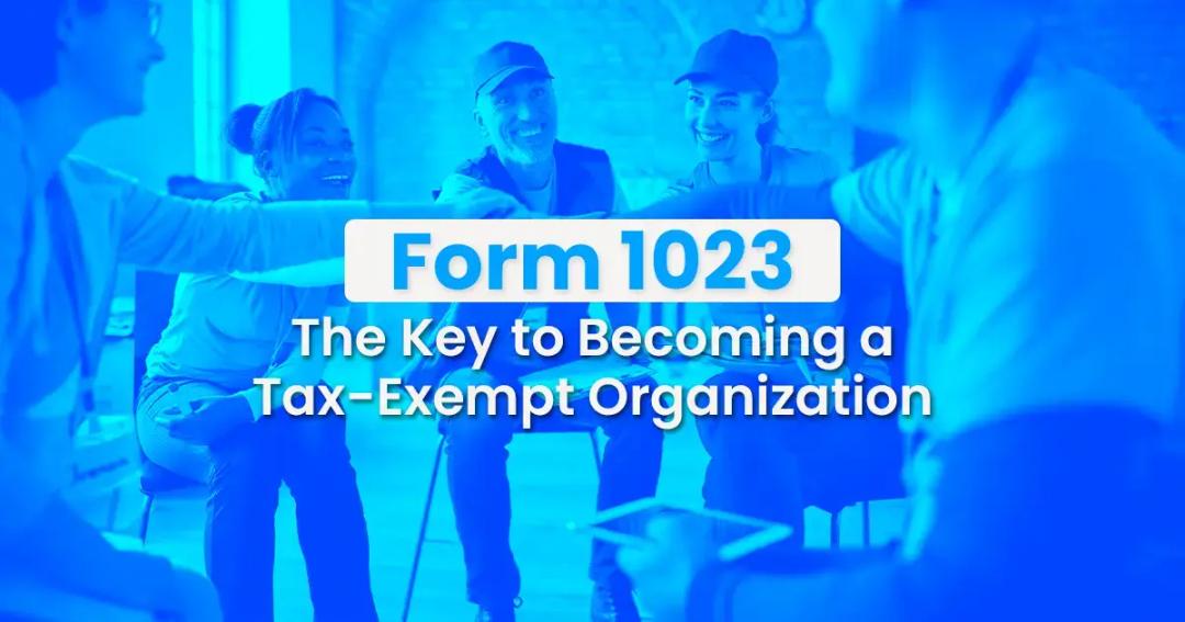 Group of professionals in a blue-tinted office discussing, with text overlay reading "form 1023 the key to becoming a tax-exempt organization".